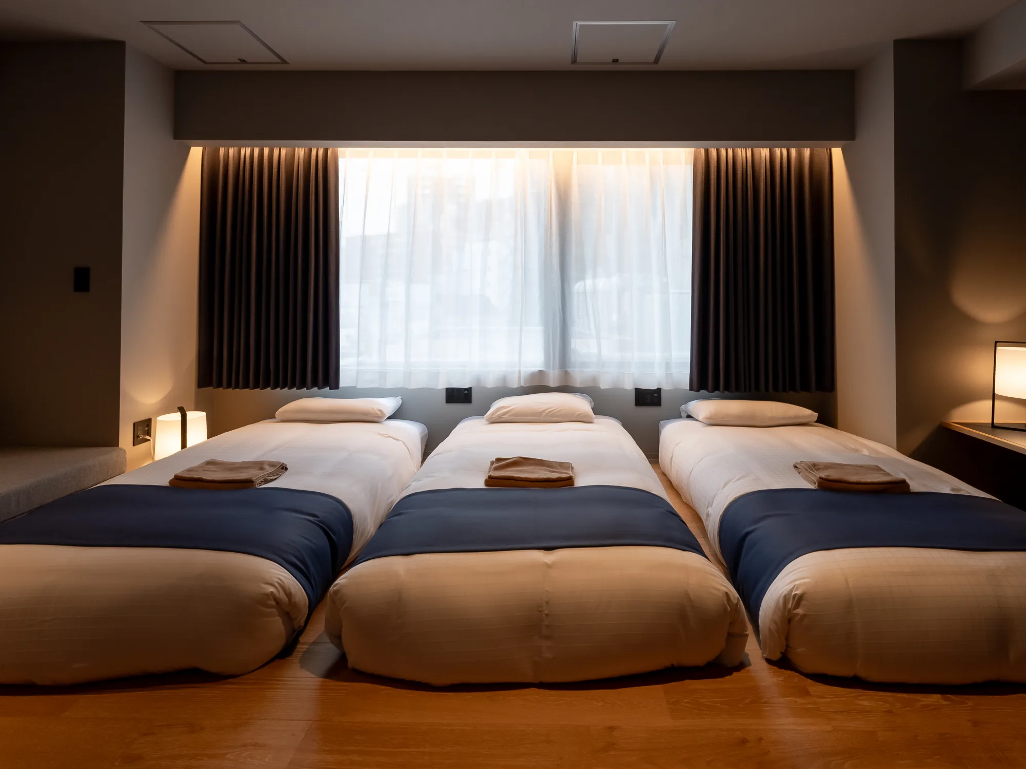 窓辺に3台のベッドを並べたSHIBUYA TRIPLE + SOFAの客室