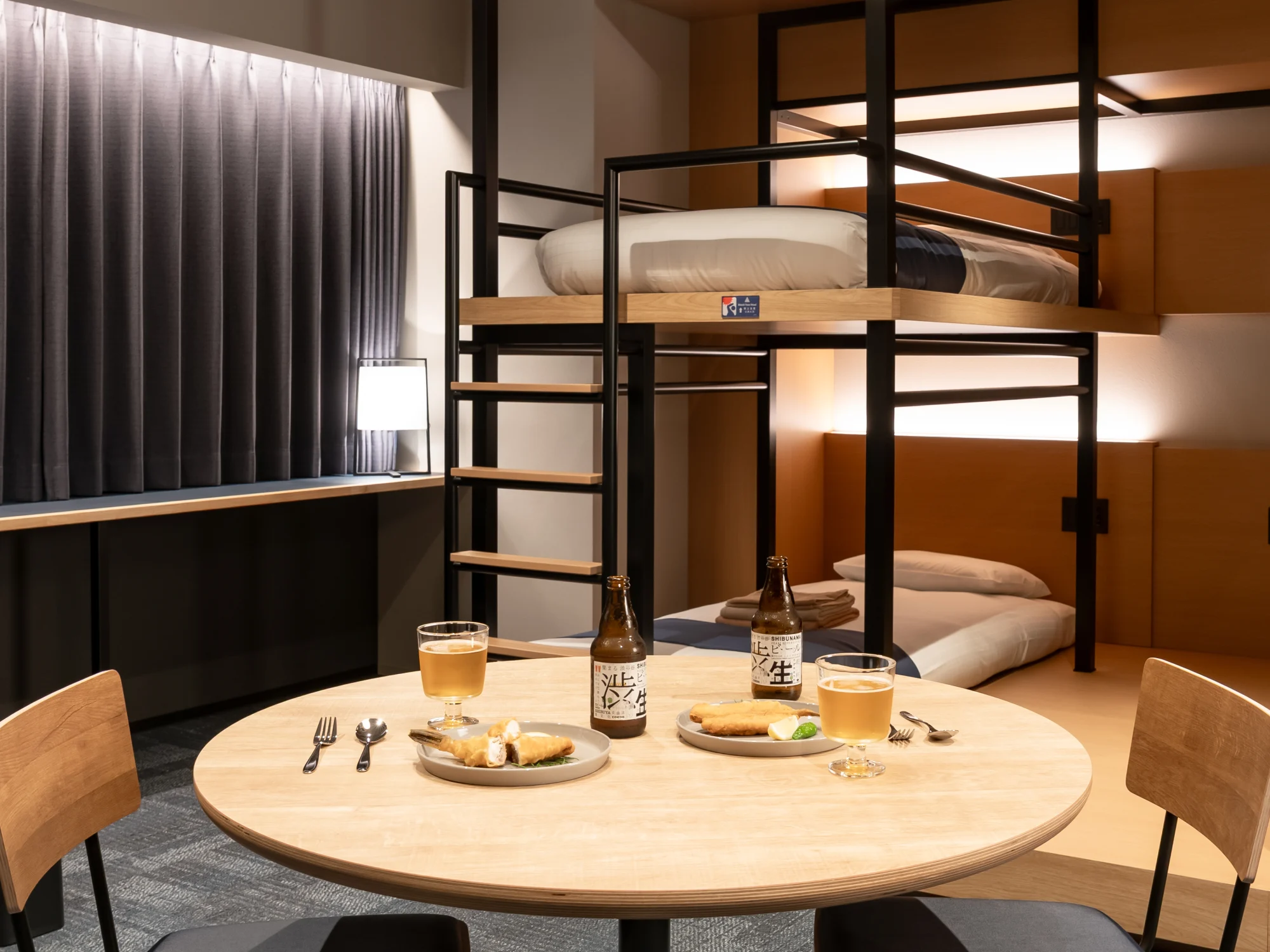 渋谷の地ビールと食事を囲むテーブル、その奥に並ぶSHIBUYA BUNKのベッド