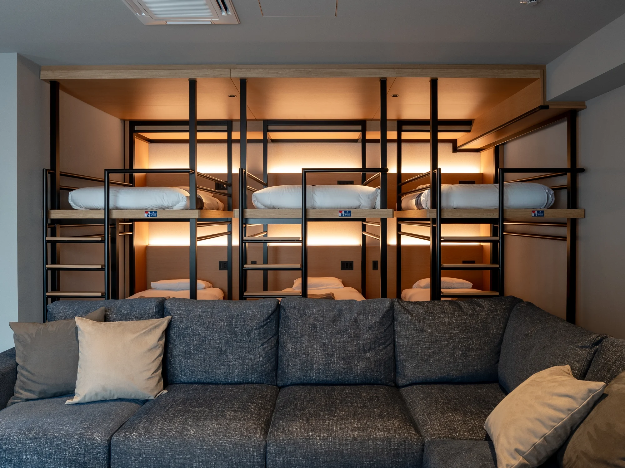 6台のベッドと大きなソファを一つの空間に備えたSHIBUYA BUNK COMFORT PLUS
